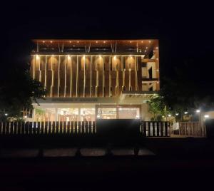 a large building with lights on it at night at RIVERSIDE MEADOWS in Vidisha