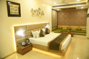a bedroom with a large bed and a couch at RIVERSIDE MEADOWS in Vidisha
