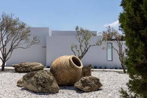 une sculpture d'un vase assis sur des rochers dans l'établissement White Holidays Project, à Tinos