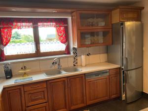 a kitchen with wooden cabinets and a stainless steel refrigerator at RanchoBachleda in Kościelisko