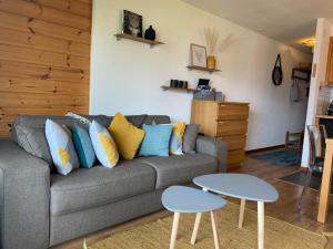 a living room with a gray couch and two tables at Studio Hauts-de-Nendaz G2 ski in-out in Nendaz
