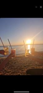 a group of drinks on the beach with the sunset at Apartments Lolo in Privlaka