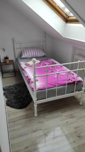 ein Bett mit einer rosa Bettdecke in einem Zimmer in der Unterkunft Apartment für Monteure Nr 4 in Kassel