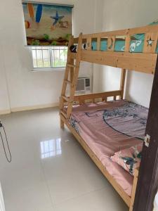 a bedroom with a bunk bed in a room at Golden Kirins Beach Resort in Lian