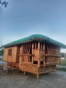 un gran edificio de madera con techo verde en Golden Kirins Beach Resort en Lian