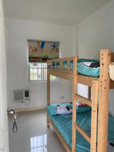 a bedroom with two bunk beds and a window at Golden Kirins Beach Resort in Lian