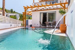 - une piscine avec une fontaine dans une maison dans l'établissement AGNONTAS LUXURY VILLAS, à Agnontas