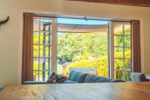 a living room with a couch and a large window at Buitenliefde, romantisch verblijf voor 2 personen in Heiloo