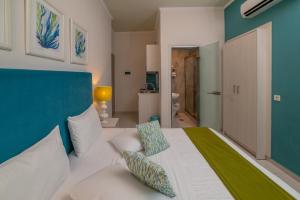 a bedroom with a white bed with a blue wall at Mansion House Parga in Parga