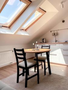 a table and chairs in a kitchen with skylights at Upės apartamentai in Birštonas