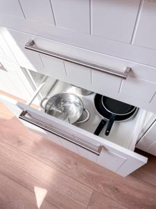 a drawer in a white kitchen with a stove at Upės apartamentai in Birštonas