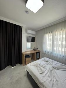 una camera con letto e scrivania di Didim Elit Otel a Didim
