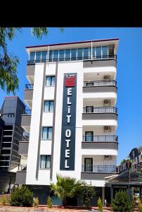 un alto edificio bianco con un cartello dell'hotel di Didim Elit Otel a Didim