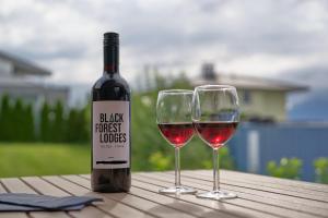 butelkę wina i dwa kieliszki wina na stole w obiekcie Black Forest Lodges - gehobene Ferienwohnungen mit Privatsaunas w mieście Tulfes