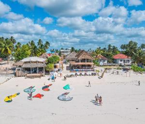 a group of people on a beach with buildings at Ananda Beach Hotel in Paje