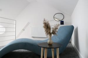 a blue couch in a room with a table and a mirror at Komfortowe mieszkanie z antresolą in Barczewo