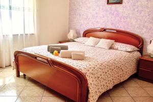 1 dormitorio con 1 cama grande con marco de madera en Casa Roberto - piano terra con giardino, en Levico Terme