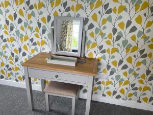 a dressing table with a mirror on a wall at The Haven at Halsons in Bridport