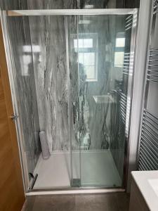 una ducha con puerta de cristal en un baño en The Haven at Halsons, en Bridport 64 fotos más