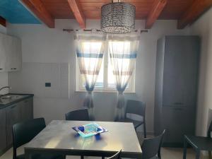 a table and chairs in a kitchen with a window at Casa vacanze “ il Tramonto” in Milazzo +9 photos