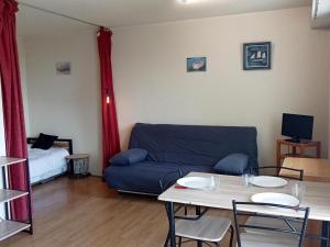 - un salon avec un canapé bleu et une table dans l'établissement Studio La Rochelle, 1 pièce, 4 personnes - FR-1-551-38, à La Rochelle