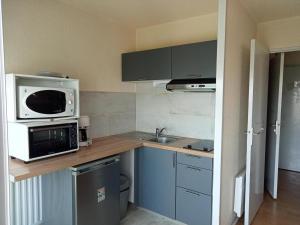 a small kitchen with a microwave and a sink at Studio La Rochelle, 1 pièce, 4 personnes - FR-1-551-38 in La Rochelle