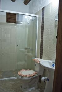 uma casa de banho com um chuveiro, um WC e um lavatório. em Casa Aparicio Lopez em Barichara