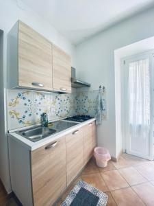 een keuken met houten kasten en een wastafel bij Cartari Apartment in Palermo