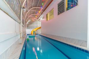ein Schwimmbad mit Rutsche in einem Gebäude in der Unterkunft Mew villa 2 pattaya in Pattaya South