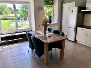 een keuken met een houten tafel met stoelen en een koelkast bij 2 Gastenverblijven in het Groene Hart nabij Utrecht 