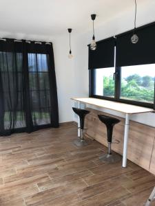 a room with a table and two windows at Gite au coeur du pays Cathare in Verzeille