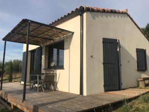 Casa pequeña con mesa y terraza de madera. en Gite au coeur du pays Cathare, en Verzeille