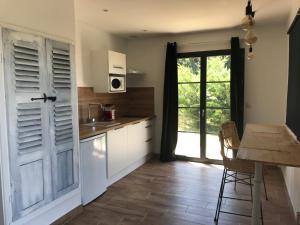 a kitchen with a table and a door with a window at Gite au coeur du pays Cathare in Verzeille