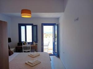 a room with a bed and a table with towels on it at Amphitrite's Haven - Cycladic House in Marpissa, Paros in Márpissa