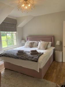 1 dormitorio con 1 cama grande y 2 toallas. en Gate lodge at Lough Erne Golf Village en Ballycassidy