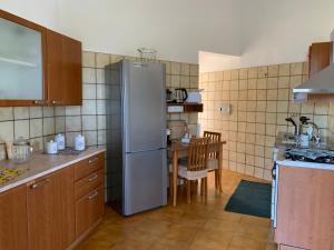 a kitchen with a stainless steel refrigerator and a table at Casa Le Cicale in Porto Istana