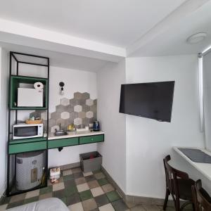 a kitchen with a table and a microwave on a wall at CASA MARGARITA 5Piso Mono Verde Oscuro in San Salvador de Jujuy