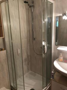 una ducha con puerta de cristal en un baño en Ferienwohnung Wasserfall, en Schliersee 5 fotos más