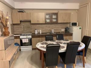 a kitchen with a table and chairs in a kitchen at Malom Vendégház in Szarvas
