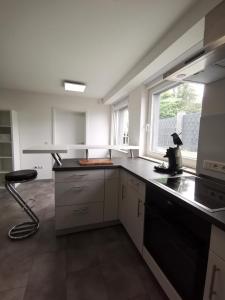 a kitchen with white cabinets and a black counter top at Moderne Wohnung mit Terrasse und eigenem Zugang. in Remscheid