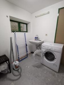 a laundry room with a washing machine and a sink at Moderne Wohnung mit Terrasse und eigenem Zugang. in Remscheid