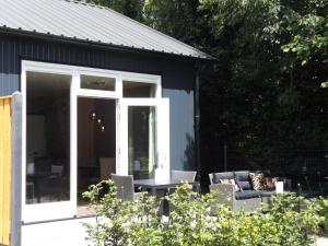 a screened in porch with a couch and a table at Het Broekeroord in Wezep