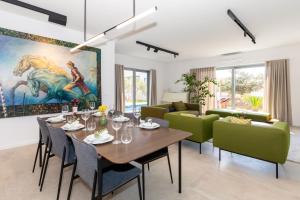jadalnia ze stołem i zielonymi krzesłami w obiekcie Luxury house Natanel w mieście Škrip