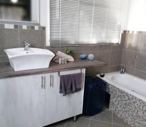 a bathroom with a sink and a bath tub at Greystoke - Furnished, self service apartment. in Springs