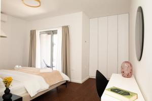 a white bedroom with a bed and a table at Luxury house Natanel in Škrip