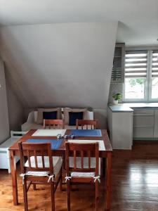 - une salle à manger avec une table, des chaises et un lit dans l'établissement Apartament Gdańsk'a, à Nowy Dwór Gdański