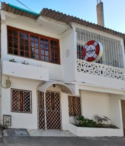 Una casa blanca con un cartel en la parte delantera. en Rivera Hostel, en Santa Marta