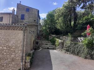 une maison en pierre avec un mur en pierre et une rue dans l'établissement Gite de Pascal et Virginie, à Ponet-et-Saint-Auban