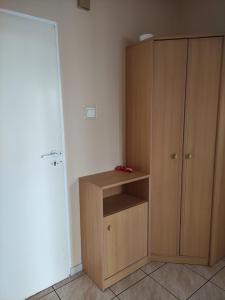 a room with a wooden cabinet next to a door at Apartament Jagiełły 14 in Giżycko