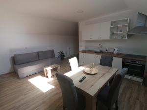a living room with a table and a couch at Farma & Apartmani OPG Sasa Delic in Korenica